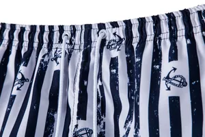 Detail of men's beach shorts featuring navy anchor print and elastic drawstring waistband