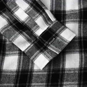 Macro detail view of black and white plaid long sleeve shirt cuff showing fabric weave