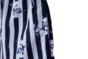 Close-up detail of nautical anchor print and vertical stripes on men's beach shorts