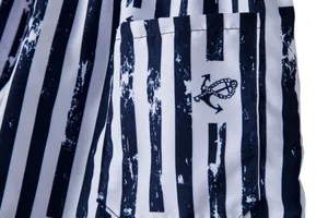 Detail view of men's striped beach shorts with anchor emblem on pocket.