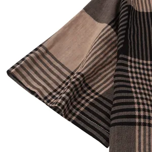 Detailed view of the stitched sleeve hem on a brown and black plaid beach shirt for men.