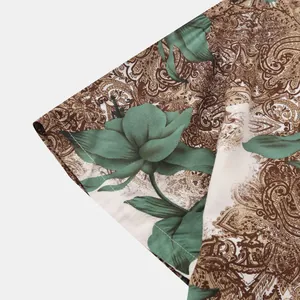 Close-up detail of a men's shirt featuring green floral and brown paisley print