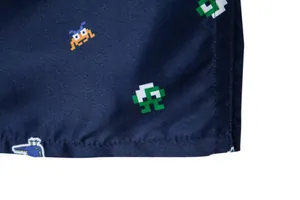 Macro view of navy blue fabric texture with colorful retro pixel monster icons