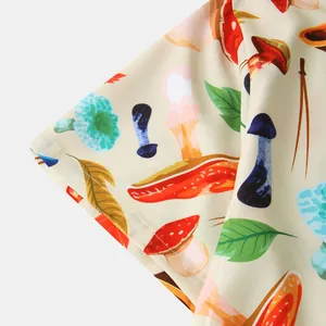 Close-up of vibrant mushroom and leaf print on beige short sleeve men's shirt