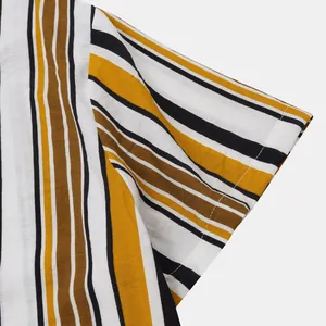 Détail de manche courte avec rayures verticales en jaune moutarde, blanc et noir.