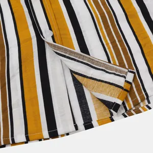 Gros plan sur le tissu à rayures jaunes et noires et les boutons d'une chemise pour homme