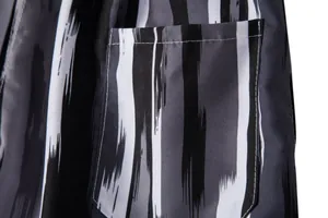 Close-up detail of men's beach shorts showing pocket stitching and striped fabric pattern