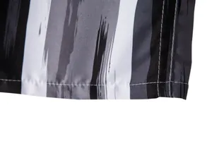 Detail view of reinforced hem stitching and brushstroke print on men's beach shorts