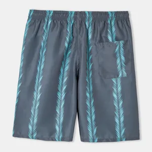 Macro view of men's grey swim trunks with blue palm leaf patterns and back pocket