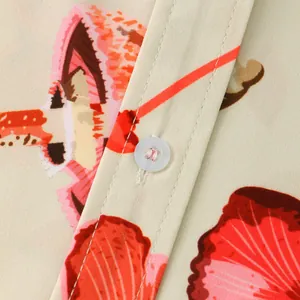 Close-up detail of casual floral short sleeve shirt with button and fine stitching.
