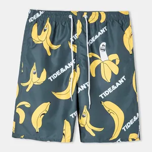 Detail view of men's dark grey beach shorts featuring a playful banana print and drawstring