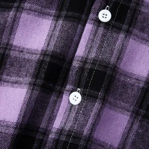 Macro view showing the fabric texture and white buttons of a purple plaid flannel shirt