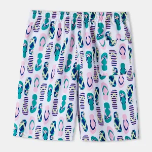 Detail view of men's beach shorts featuring a colorful flip-flop pattern and back pocket