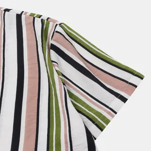 Détail rapproché de la texture du tissu et des coutures d'une chemise à rayures vert