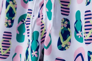 Detailed macro view of men's quick-dry beach shorts with vibrant flip-flop print and drawstring