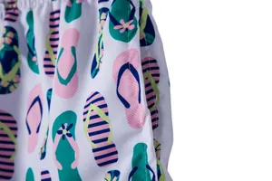 Close-up detail of men's beach shorts featuring vibrant flip-flop pattern and pocket.