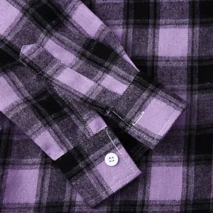 Close-up detail of a purple and black plaid shirt sleeve cuff featuring a white button