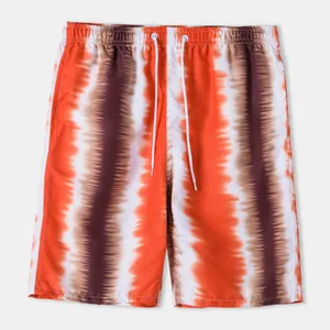 Detail view of men's beach shorts featuring vibrant orange and brown tie-dye vertical stripes.