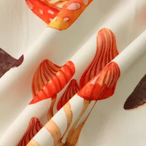 Close-up of soft breathable fabric with orange mushroom print for men's shirt