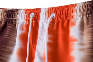 Detailed close-up view of tie-dye beach shorts waistband with adjustable white drawstring.