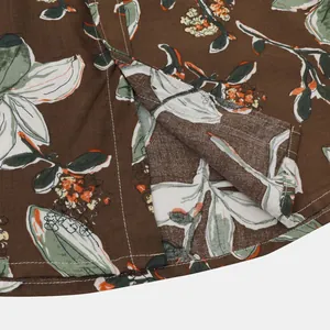 Gros plan de la fente de l'ourlet d'une chemise à fleurs marron pour homme.