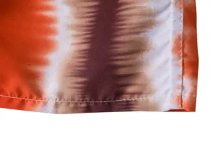Macro view showing high-quality stitching and orange tie-dye pattern on men's beach shorts