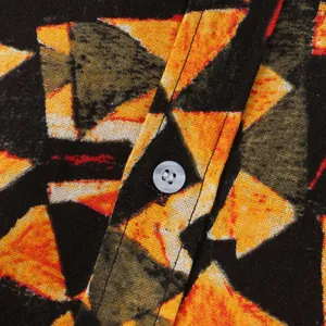 Nahaufnahme von geometrischem Musterstoff und weißem Knopf am Herren-Strandhemd.