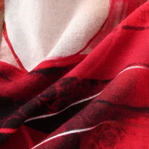 Detailed macro view of red ethnic floral print and woven fabric texture on a casual men's shirt