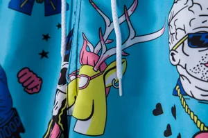 Close-up detail of light blue men's beach shorts with vibrant cartoon pop art print