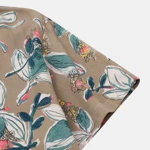 Gros plan de la manche d'une chemise de plage pour hommes avec imprimé floral kaki et sarcelle.
