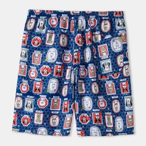 Detailed macro view of blue men's beach shorts with repeating cartoon dog pattern print