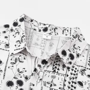 Close-up of a white men's short sleeve shirt featuring a black floral print and size M label