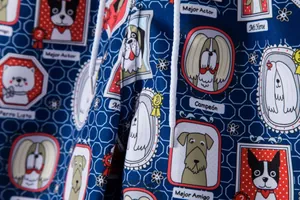 Detailed close-up of men's blue beach shorts featuring a playful cartoon dog portrait print.