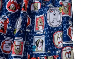 Close-up of men's blue beach shorts featuring a playful cartoon dog print and pocket detail.