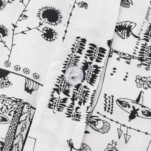 Macro view of white men's shirt featuring black botanical print and button detail.