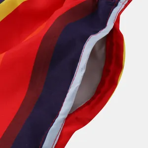 Close-up detail of side pocket on vibrant multi-colored striped beach shorts