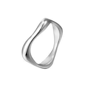 Vue macro montrant le design ondulé irrégulier minimaliste de la bague en acier titane argenté