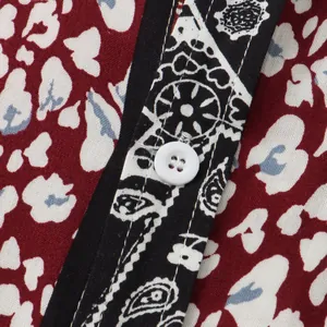 Macro close-up showing the white button and intricate floral print of a men's shirt