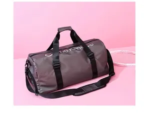 Vue détaillée d'un grand sac de sport gris posé sur un fond rose élégant et moderne