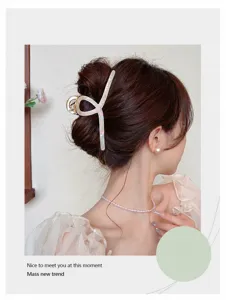 Detalle de una pinza para el pelo grande de acetato jaspeado en un recogido elegante.