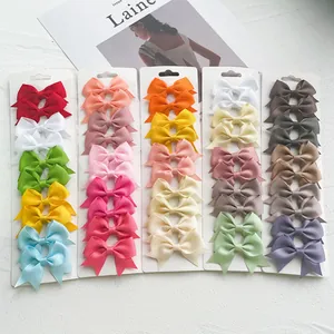 Detailed view of colorful grosgrain ribbon mini bow hair clips set on white cards