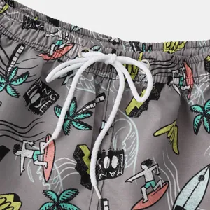 Close-up detail of cartoon surfing print and white drawstring on gray men's beach shorts