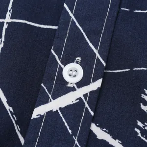 Gros plan du bouton blanc et du motif à carreaux sur chemise de plage bleu marine