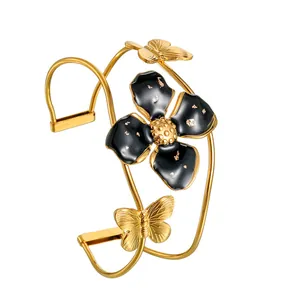Elegantes goldenes Edelstahl-Armband mit großer schwarzer Blume und Schmetterlings-Detail