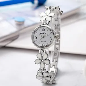 Close-up of elegant silver women's bracelet watch with white flower charms
