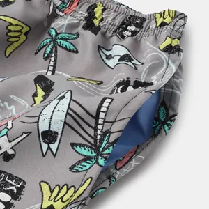 Close-up of men's quick-dry beach shorts fabric with surf print and pocket detail.