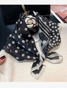 Close-up of vintage black and white polka dot silk cotton scarf with flower pin