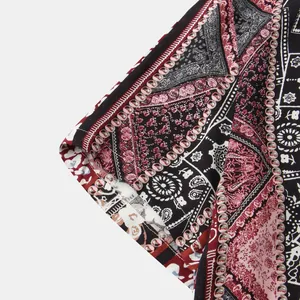 Close-up of men's floral shirt sleeve featuring vibrant paisley and geometric patterns.