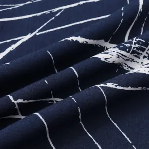 Vue rapprochée d'un tissu bleu marine avec des motifs linéaires abstraits blancs