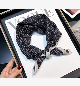 Close-up view of black and white silk cotton scarf with paisley pattern and knotted detail
